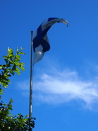 Suomen lippu liehuu kesätuulessa.
