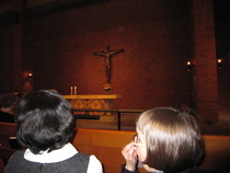 Alttariveistos Kristus ristillä (kuvanveistäjä Laila Pullinen) kirkon penkistä nähtynä. 