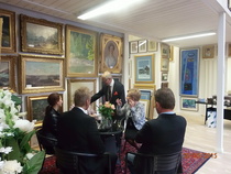 Joukko avajaisvieraita keskustelemassa isäntäpariskunnan kanssa.