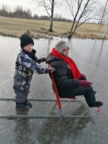 Viktor ja mummi kelkkoineen lammen jäällä "talvella" 2020.