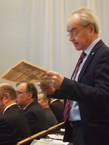 Osanottajilla oli mahdollisuus tehdä kysymyksiä alustajille. Tässä Poppe Taucher selaa ruotsalaista lehteä ja kysyy lehdessä olevan jutun perusteella Suomen ja Ruotsin välisestä maanpuolustustusyhteistyöstä alustajalta.