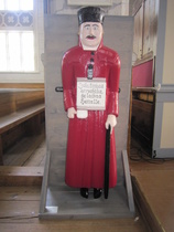 "Joka köyhää armahtaa, hän lainaa Herralle". Teksti on monessa vaivaisukossa ja  tämä puna-asuinen ukko on Kälviältä vuodelta 1820.