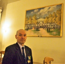 Illallinen nauttiin Haminan upseerikerholla. Kerhon suurta ruokasalia koristaa taistelumaalari Hugo Backmanssonin Haminan vanhaa kadettikoulua kuvaava taulu vuodelta 1939. Etualalalla yksi  päivän osanottajista ja pöytämme kadettiupseeri.